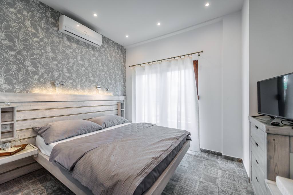 tende bianche nel design della camera da letto con carta da parati grigia