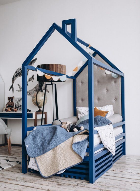 letto blu a forma di casa in una cameretta
