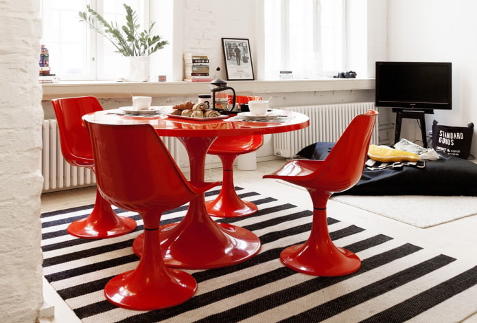 tavolo rotondo rosso nell'interno della cucina-soggiorno