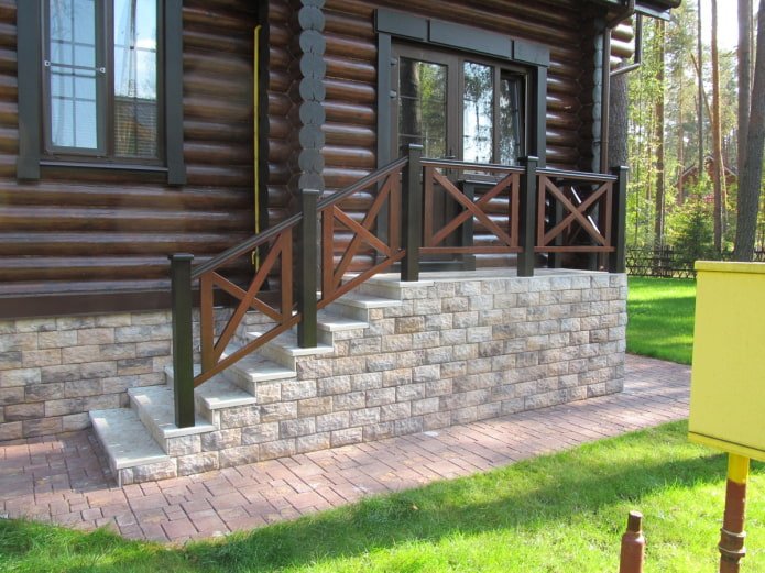 portico in pietra vicino a una casa in legno