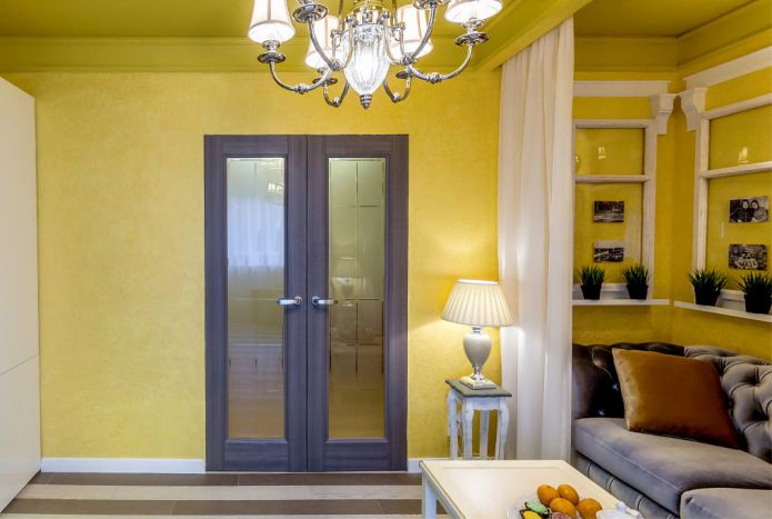 combinazione di pareti gialle con una porta marrone scuro con inserti in vetro