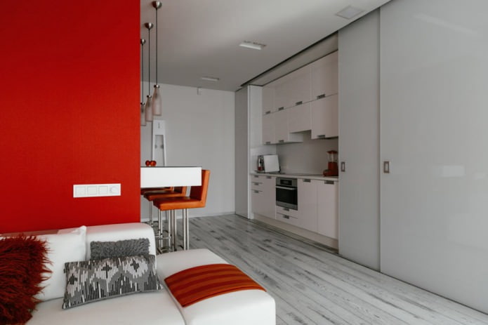 Bancone bar all'interno della cucina-soggiorno nei toni del bianco e del rosso
