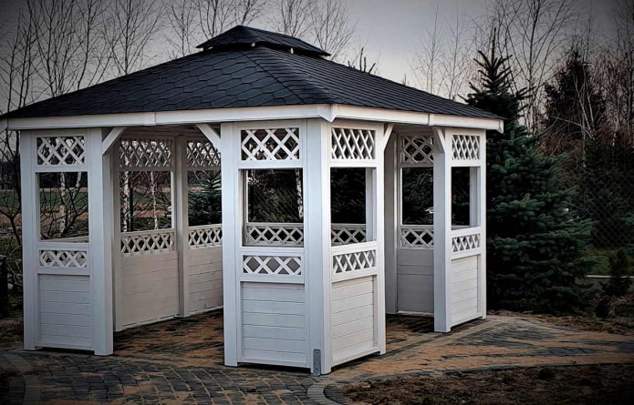 gazebo in assi di legno bianche con decorazioni a listelli
