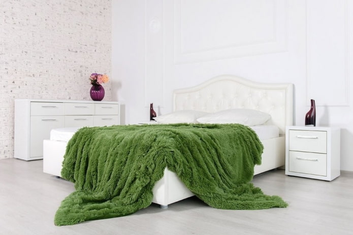 letto con un copriletto in erba in camera da letto