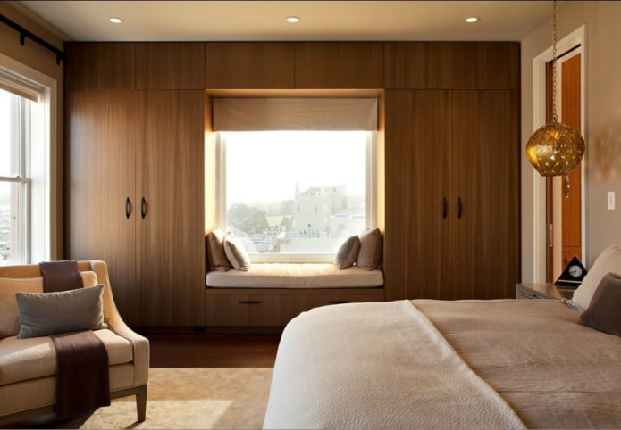 armadietti intorno alla finestra nell'arredamento della camera da letto