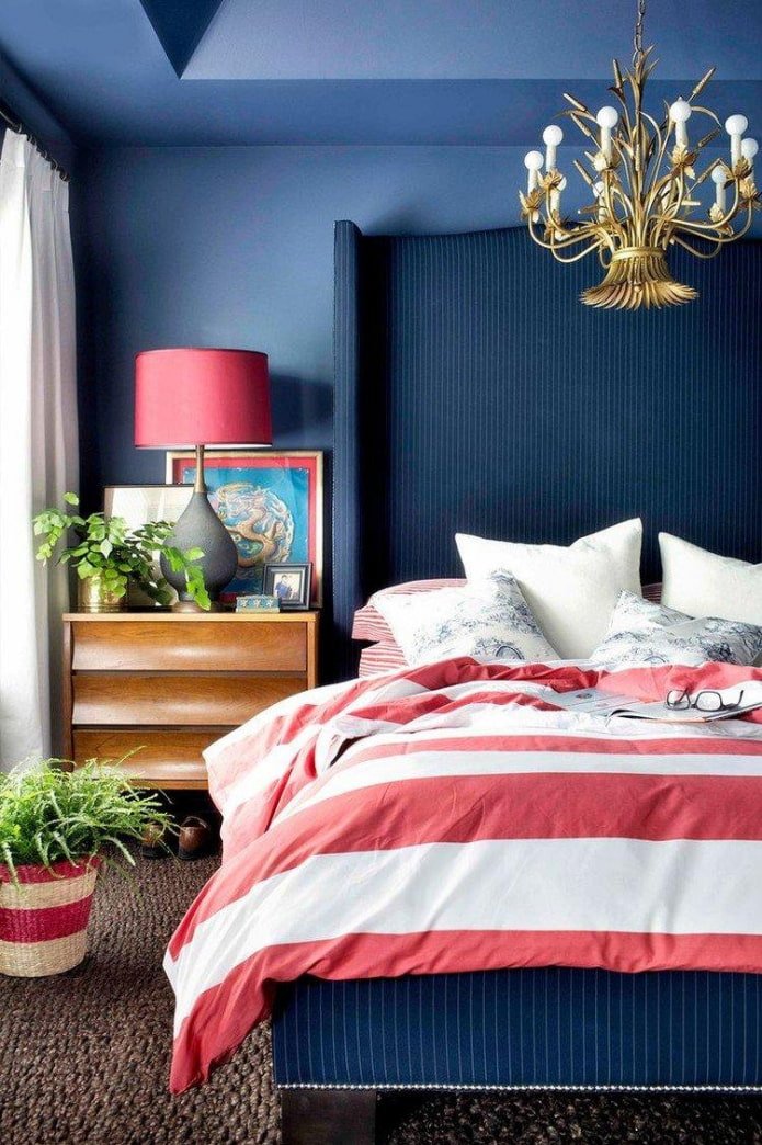 una camera da letto blu con accenti rossi