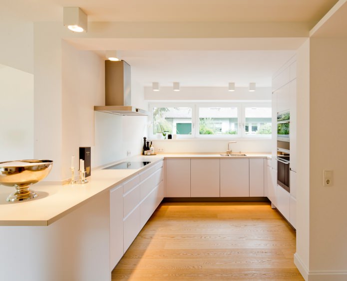 interno cucina bianca con piano di lavoro color vaniglia
