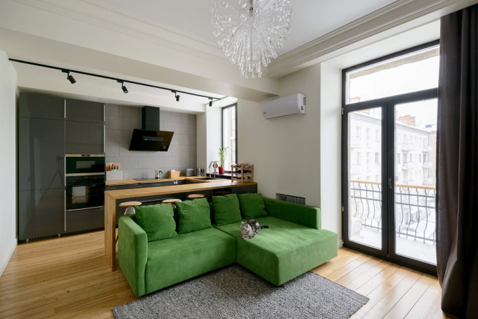divano verde nell'interno della cucina-soggiorno