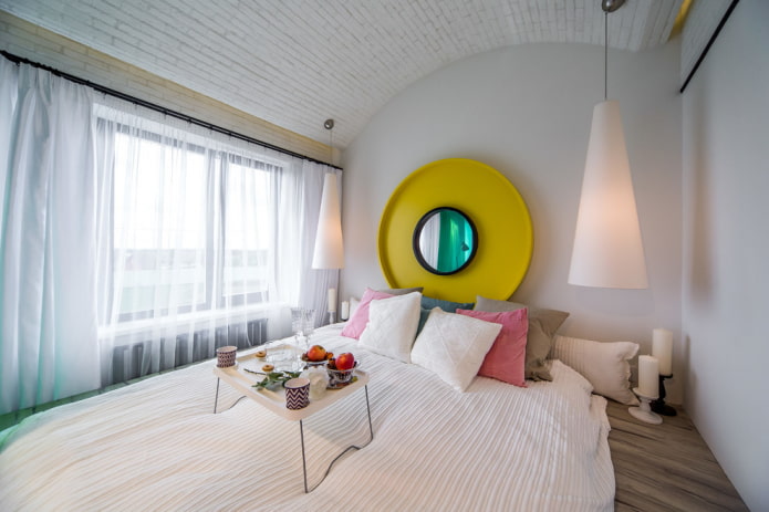 specchio sopra il letto nell'interno della camera da letto