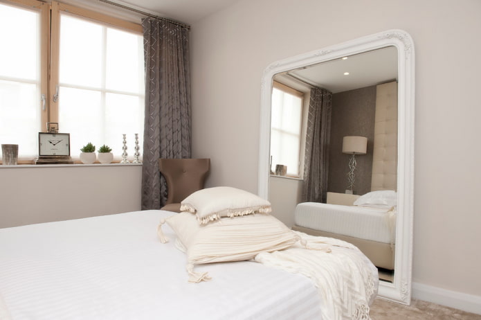 specchio con cornice bianca nell'interno della camera da letto