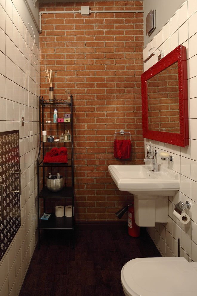 specchio con cornice rossa all'interno del bagno