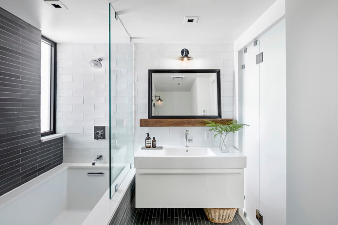 specchio con cornice nera all'interno del bagno