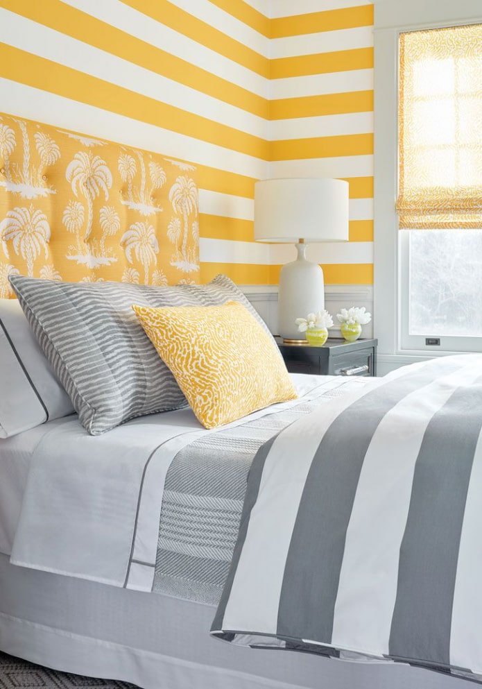 camera da letto nei toni del giallo e del grigio con carta da parati a righe